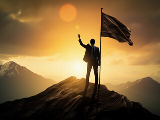 Backlit image of a Silhouette of a businessman holding a flag on the top of the mountain 