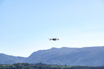 drone in flight recording a green mountain landscape with a blue sky
