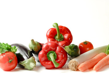 group of assorted vegetables on white background and copy space. bell pepper, leek, tomato, zucchini, aubergine.