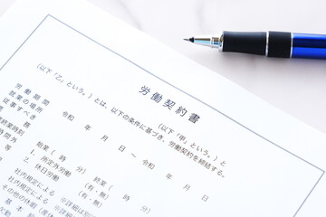 使用者と労働者の間で賃金や労働時間などの労働条件について書面にまとめた労働契約書にサインする