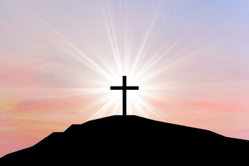 Cross on top of the mountain at sunset, crucifix with sunbeam light in the background. Cross on a...