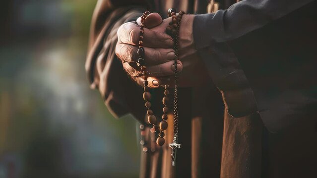 Closeup of monk's hands holding a rosary