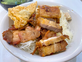 A Bowl of Delicious rice noodles Pangsit (bihun Pangsit) . Various pork meat rice noodles with dumpling and fried dump