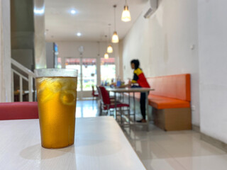 Iced tea and ice, fresh drink with interior bokeh background. a glass of iced tea