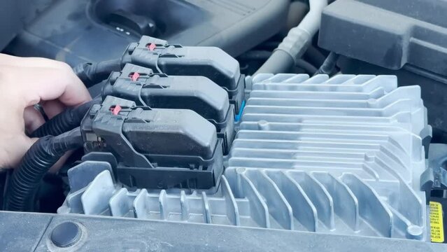 A mechanic disconnecting a Chevy Equinox Engine Computer Control Module during the winter.