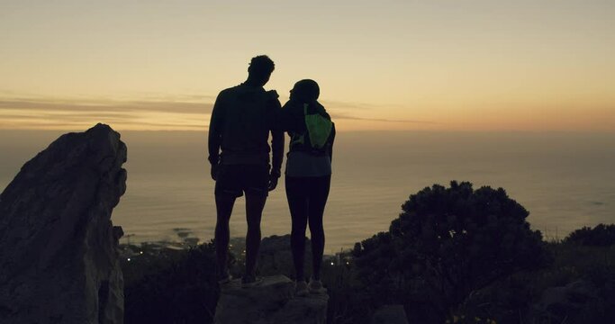Couple, silhouette and hiking on mountain in nature, view and travel for sunset in climbing adventure. Man, woman and excited in trekking by rock cliff, environment and outdoor wellness by exercise