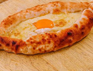 Ajarian Khachapuri, filled with cheese and topped with egg yolk