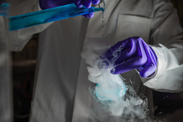 Smoky experiments with blue droplets. Scientist working on chemical reaction,