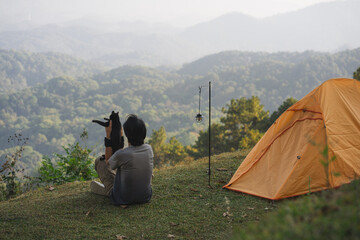 landscape and travel concept with solo freelancer man relax and play with cat and see sunset with...