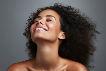 Beautiful smiling afro woman touching her flawless glow, perfect skin care and confidence