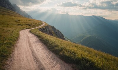 Curved rural road in the mountains. Sun rays from clouds at sunset