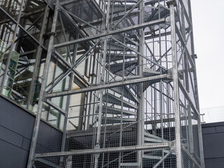 Transparent emergency staircase cladding made with wire mesh. External fire escape spiral...