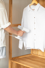 A man uses a steamer to steam a shirt