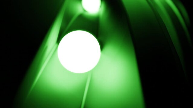 Small light balls rolling among narrow metal track. Design. Shining white spheres on path.