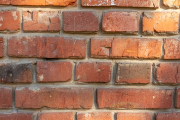 Weathered dark brick background. Close-up view of old molded red brick wall covered with cracks and scratches. Copy space for your text and decorations. Demolition theme.