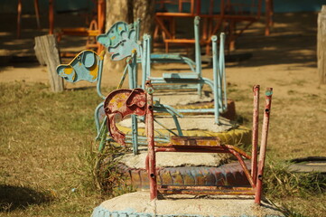 Fototapeta na wymiar Four rocking horses are made in the shape of animals and made of steel in an outdoor playground in Thailand.