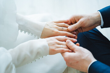 The man gently slides the wedding ring onto the womans finger during the event
