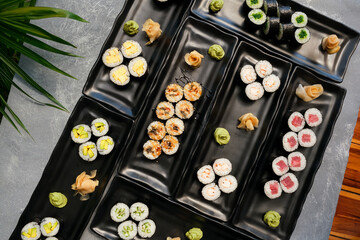 Obraz na płótnie Canvas Rainbow Sushi Roll with salmon, eel, tuna, avocado, royal prawn, cream cheese Philadelphia, caviar tobica, chuka. Sushi menu. Japanese food.