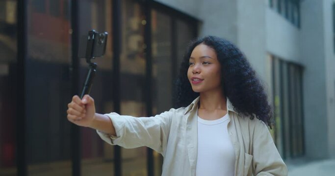 Beautiful young African woman uses phone and broadcasts live in the city She uses and creates content on social media platforms with a smile in the city.