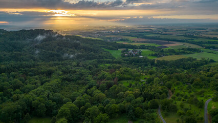 Stunning aerial view of sun setting over forests, hills and fields in rural Hohenlohe in southern...