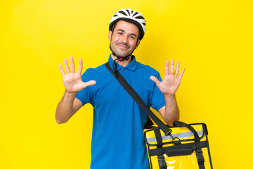 Young handsome man with thermal backpack over isolated yellow background counting ten with fingers