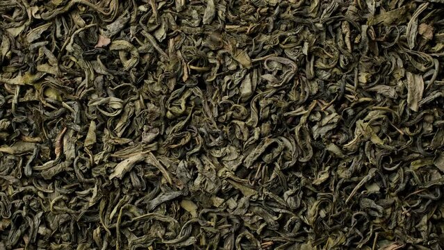 Heap of dry leaves green tea top view, rotation
