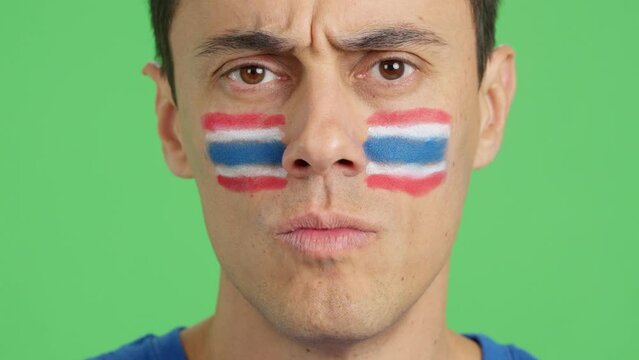 Serious man with a thai flag painted on the face