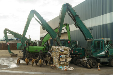 Industrial Waste Management With Green Excavators at a Recycling Facility During Daytime Operations