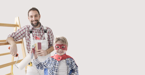 Professional painter and superhero boy painting a home