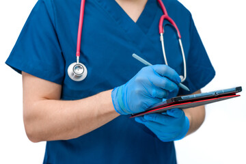 Lekarz ubrany w niebieski kitel medyczny pisze na tablecie, wystawia skierowania na badania i recepty - obrazy, fototapety, plakaty
