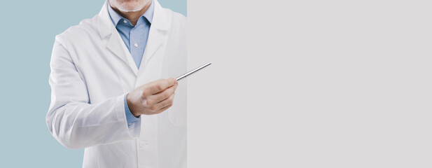 Doctor showing a blank sign and pointing with a pen