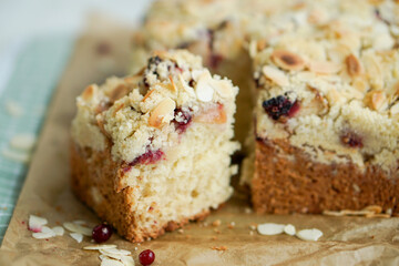 Home made coffee cake with apples with cramb topping and almond slices on crafte background close up selective focus