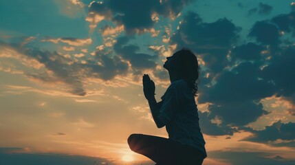 Silhouette of woman kneeling down praying for worship God at sky background. Christians pray to jesus christ for calmness. In morning people got to a quiet place and prayed. copy space - obrazy, fototapety, plakaty