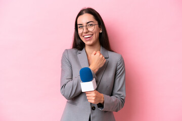 Young caucasian tv presenter woman isolated on pink background showing ok sign with fingers