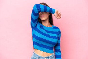 Young caucasian woman isolated on pink background covering eyes by hands