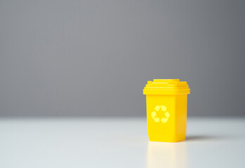 Yellow recycling bin and copy space. Circular economy. Conserve natural resources, reduce waste, create jobs in recycling industry. Selling recycled material or getting grants for green projects.