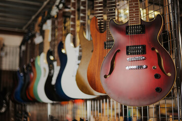 Many different electric guitars hanging on wall of music store