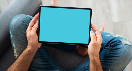 Black tablet device mockup in male hands. Top view.