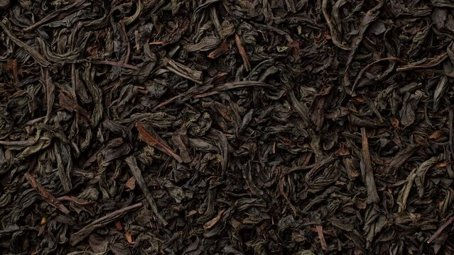 Heap of dried black tea leaves top view, rotation