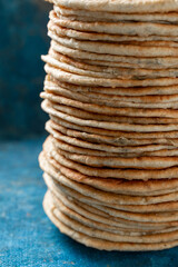 Flatbread lavash, chapati, naan, heap of tortilla on a blue background Homemade flatbread stacked.