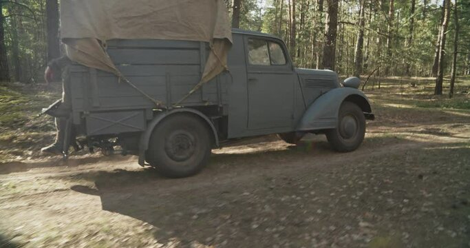 German Vehicle Truck Opel Blitz Driving By Forest Road In Autumn Season. Military Truck Opel. Reenactment Tactic Game. German Wehrmacht World War Ii Military Automotive.