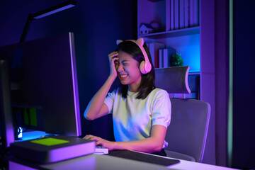 Young Asian gamer girl feeling upset after lose the online games.