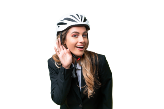 Business Uruguayan woman wearing a helmet biker over isolated background listening to something by putting hand on the ear