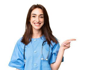 Young nurse woman over isolated chroma key background pointing finger to the side