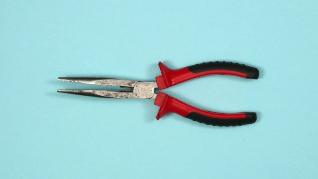 Long nose pliers. Tools in action on color background. Loopable stop motion animation. 4K top view. DIY video concept.