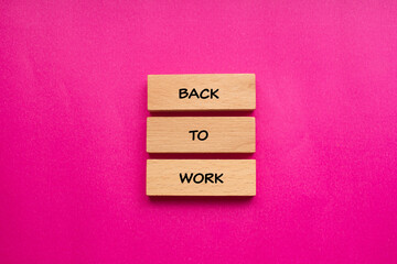Back to work words written on wooden blocks with pink background. Conceptual business symbol. Copy space.