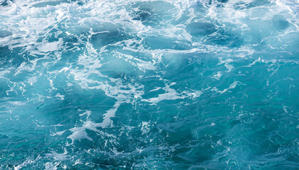 Background shot of aqua sea water surface with foam and copy space