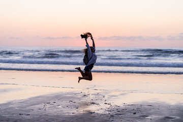 Fototapeta na wymiar woman jumping on the beach at sunset