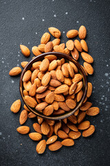 Almond nuts in bowl at black background.