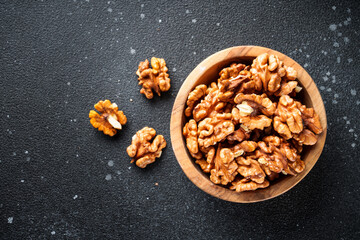 Hazelnuts in bowl at black background.